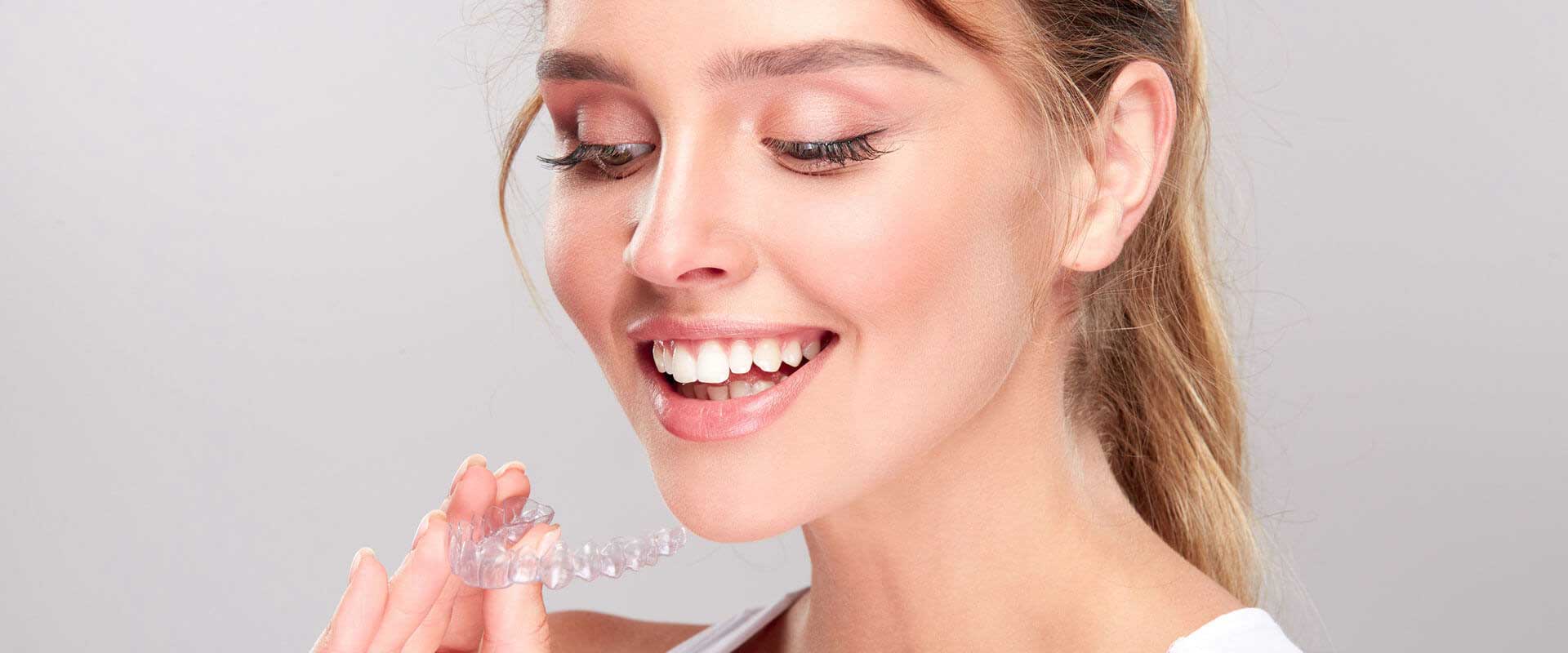 A woman happily showing off her Invisilgn while smiling 